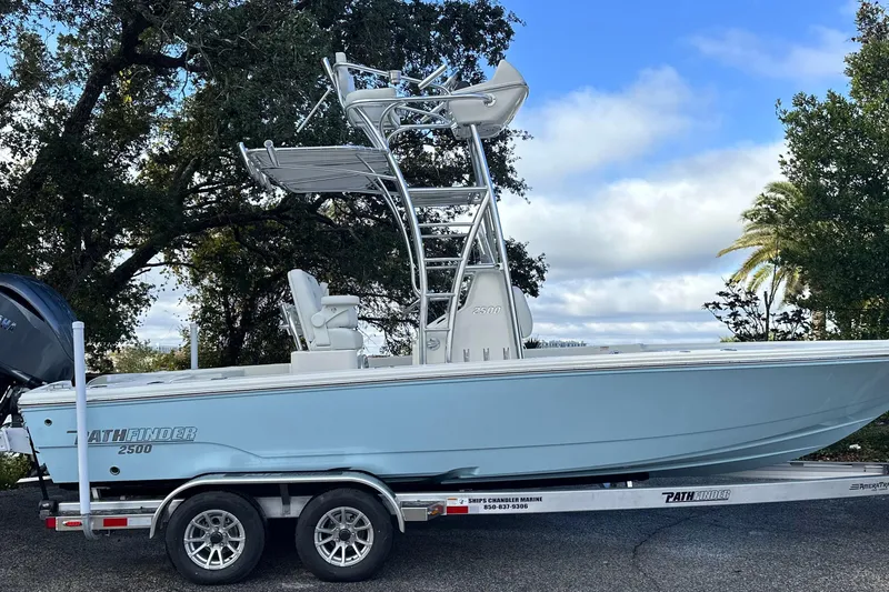 Slide: The Image of 2026 Pathfinder 2500 Hybrid boat on trailer, parked outdoors under a cloudy sky. - 26
