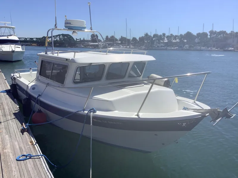 Slide: The Image of 2007 SeaSport 2400 XL boat docked in a marina under clear blue skies. - 1