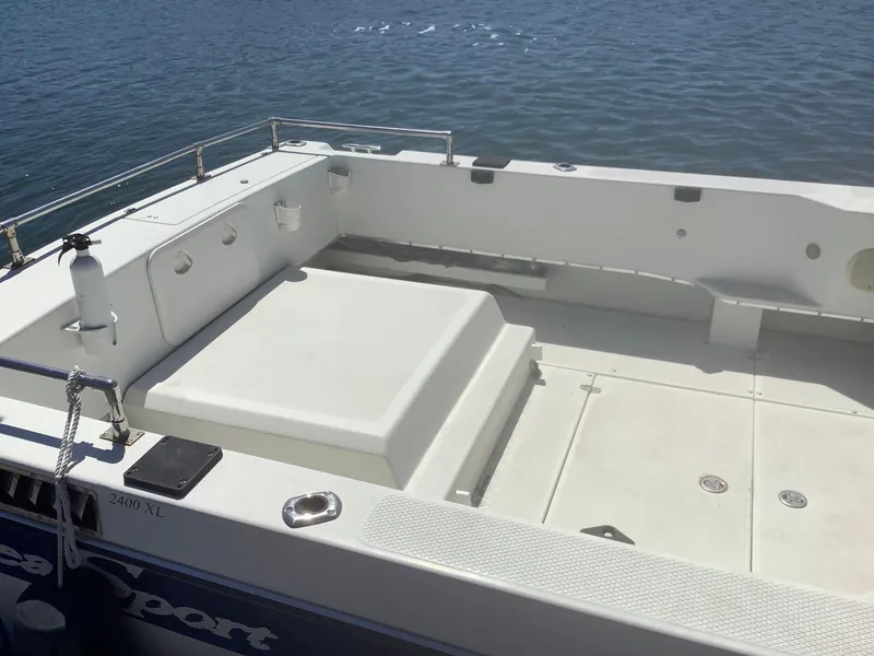 Slide: The Image of 2007 SeaSport Explorer 2400 boat deck with seating, docked on calm water. - 10