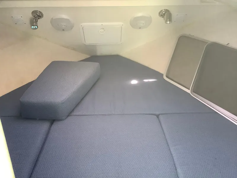 Slide: The Image of 2007 SeaSport Explorer 2400 cabin interior with blue cushions and overhead lighting. - 6
