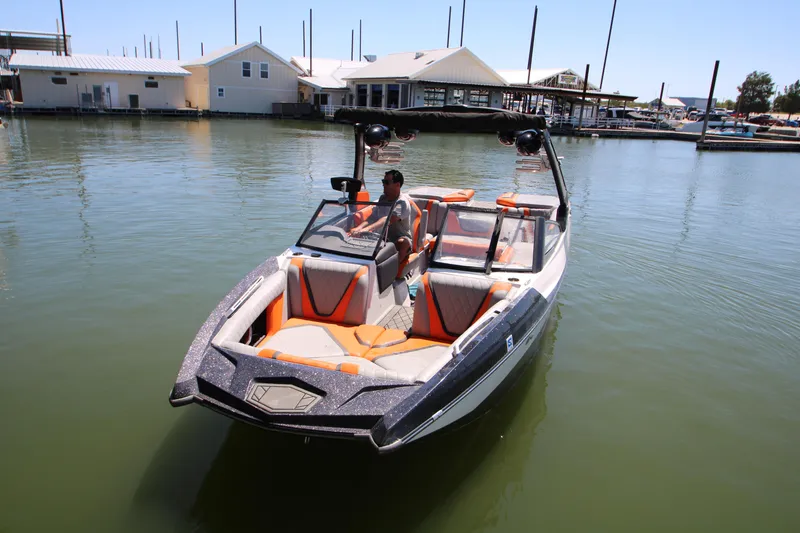 Slide: The Image of 2017 Tigé RZX3 boat on calm water near a marina. - 1