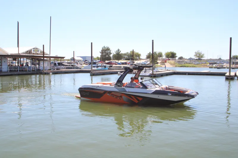 Slide: The Image of 2017 Tigé RZX3 boat cruising in a marina with clear skies. - 11
