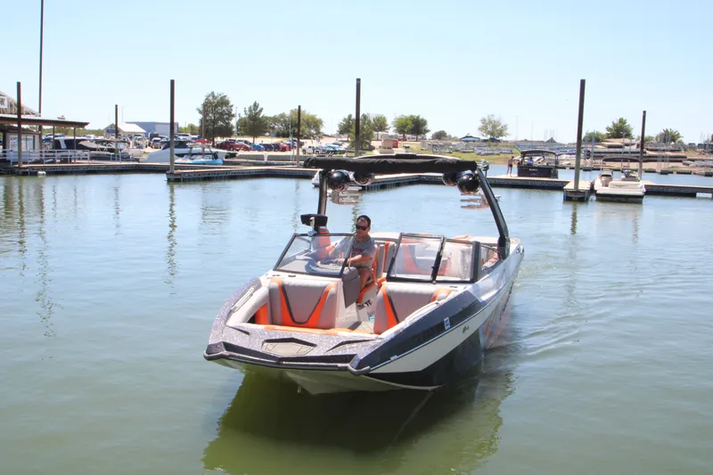 Slide: The Image of 2017 Tigé RZX3 boat on calm water near a marina. - 14