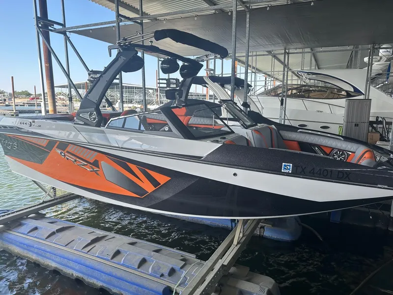 Slide: The Image of 2017 Tigé RZX3 boat in dock, featuring sleek orange and black design. - 16