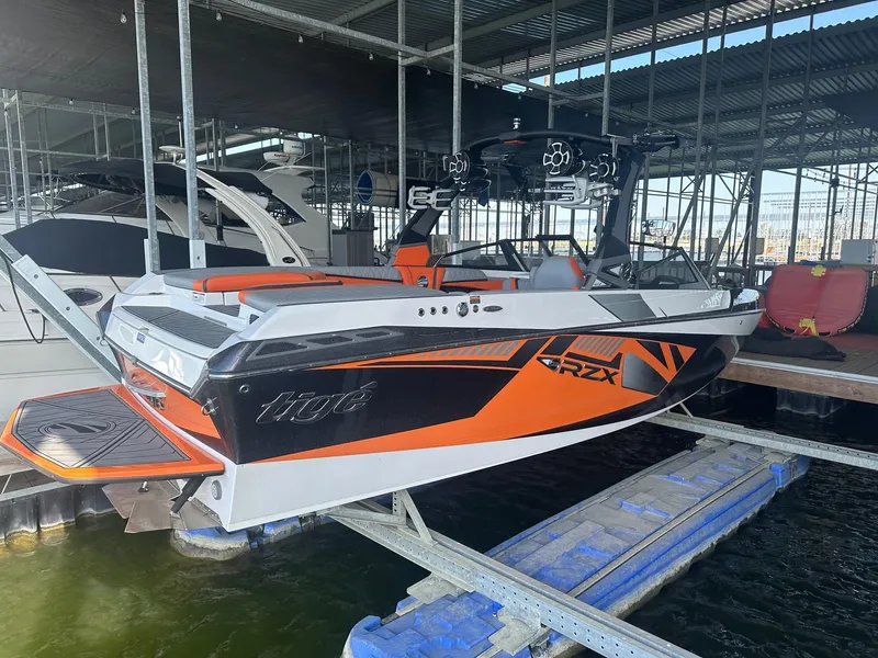 Slide: The Image of 2017 Tigé RZX3 boat in dock, featuring sleek orange and black design. - 17