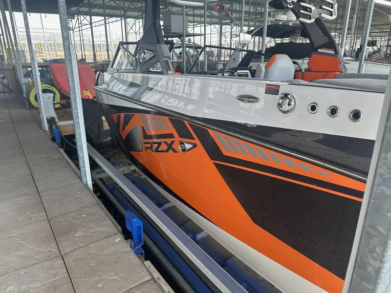 Slide: The Image of 2017 Tigé RZX3 boat in dock, featuring orange and black design. - 18