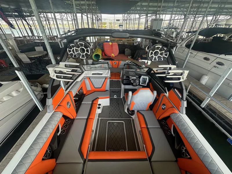 Slide: The Image of 2017 Tigé RZX3 boat interior with orange and gray seating, advanced audio system, and sleek design. - 2