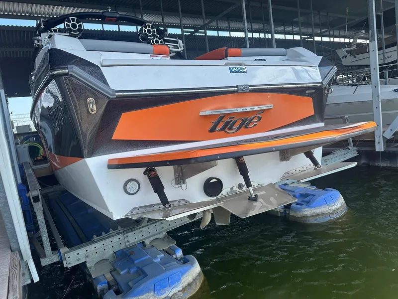 Slide: The Image of 2017 Tigé RZX3 boat in dock, featuring orange and black design. - 20