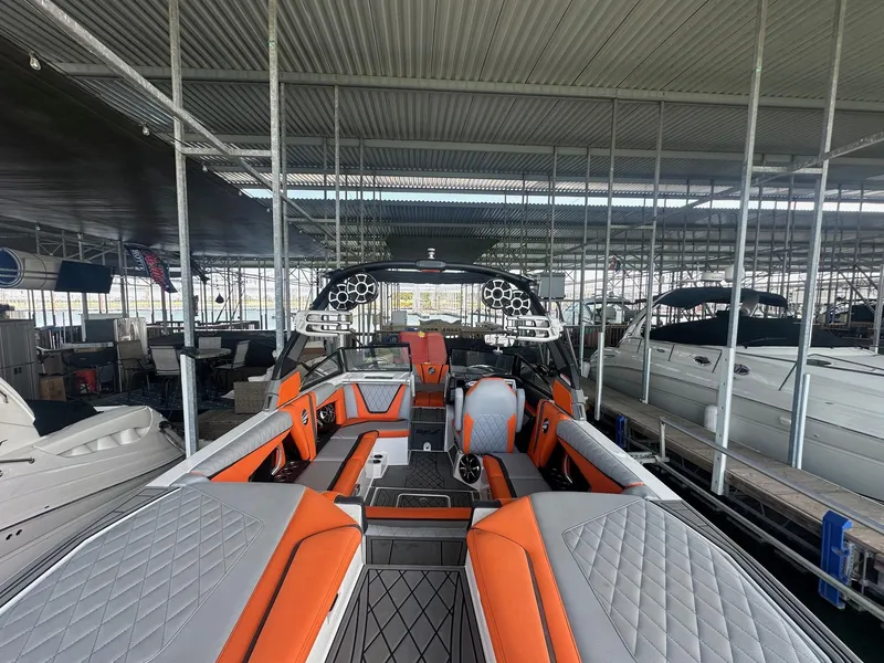 Slide: The Image of 2017 Tigé RZX3 boat with orange and gray interior in a covered marina. - 21