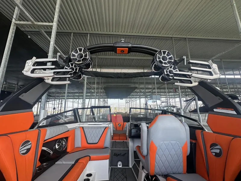 Slide: The Image of 2017 Tigé RZX3 boat interior with orange and gray seating, advanced sound system, and sleek design. - 25