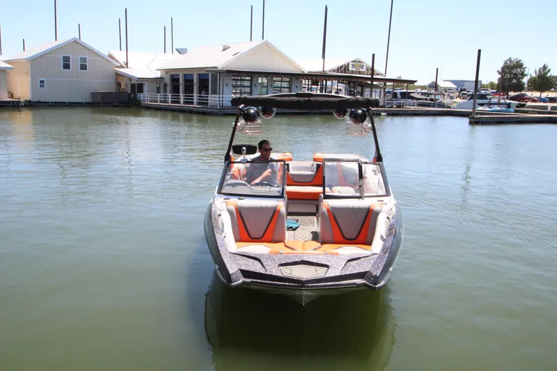 Slide: The Image of 2017 Tigé RZX3 boat on calm water near marina buildings. - 3
