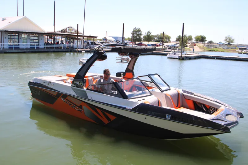 Slide: The Image of 2017 Tigé RZX3 boat in marina, featuring sleek design and vibrant orange accents. - 5