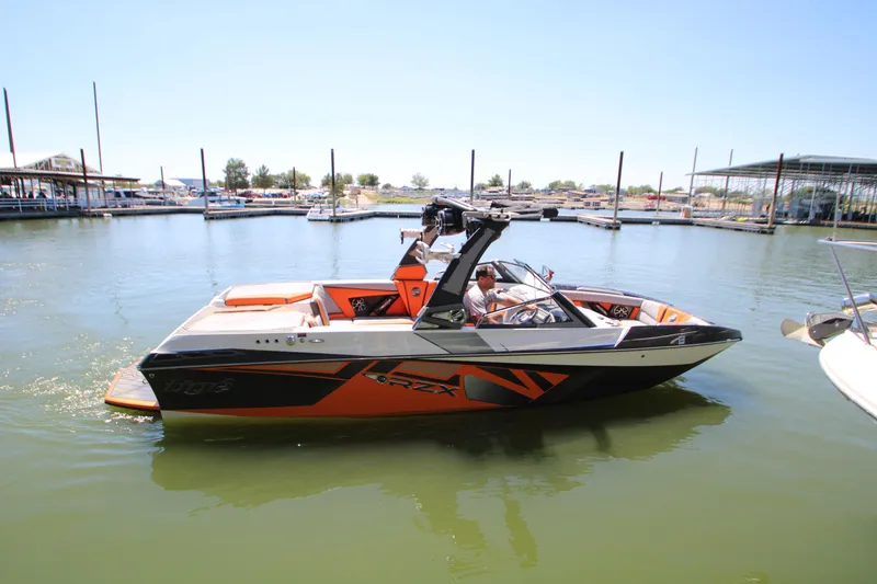 Slide: The Image of 2017 Tigé RZX3 boat in marina, featuring sleek orange and black design. - 6