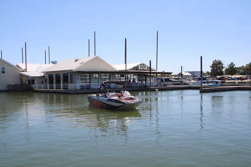 Slide: The Image of 2017 Tigé RZX3 boat on calm water near a marina. - 8