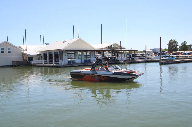Slide: The Image of 2017 Tigé RZX3 boat on calm water near a marina. - 9