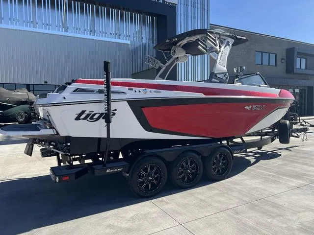 Slide: The Image of 2021 Tigé ZX Class 25 ZX boat on trailer, red and white design. - 3