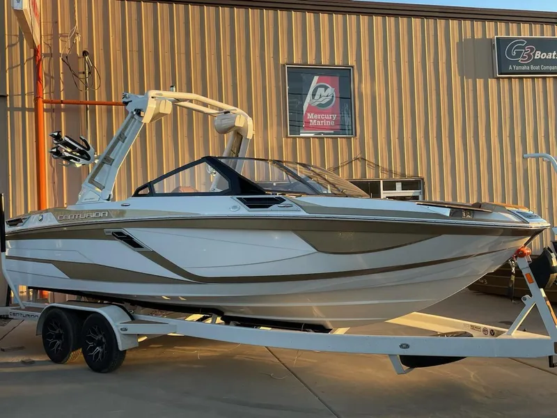 Slide: The Image of 2024 Centurion Ri230 boat on trailer outside dealership. - 2