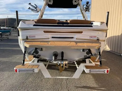Slide: The Image of 2024 Centurion Ri230 boat rear view with teak swim platform and wakeboard racks. - 3