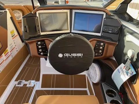 Slide: The Image of 2024 Centurion Ri230 boat dashboard with dual screens and Gussi Italia steering wheel. - 5