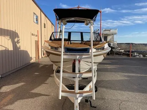 Slide: The Image of 2024 Centurion Ri230 boat parked outdoors, front view, under clear blue sky. - 6