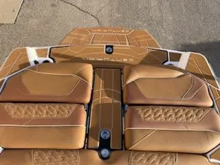 Slide: The Image of 2024 Centurion Ri230 boat with tan cushioned seats and sleek design. - 9