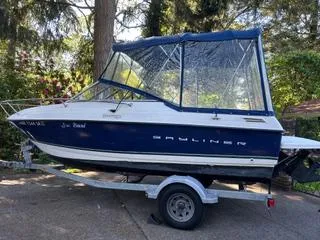 Slide: The Image of 2012 Bayliner 192 Discovery Cuddy boat on trailer, parked outdoors. - 14