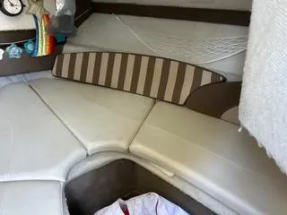 Slide: The Image of 2012 Bayliner 192 Discovery Cuddy cabin interior with cushioned seating and storage. - 7