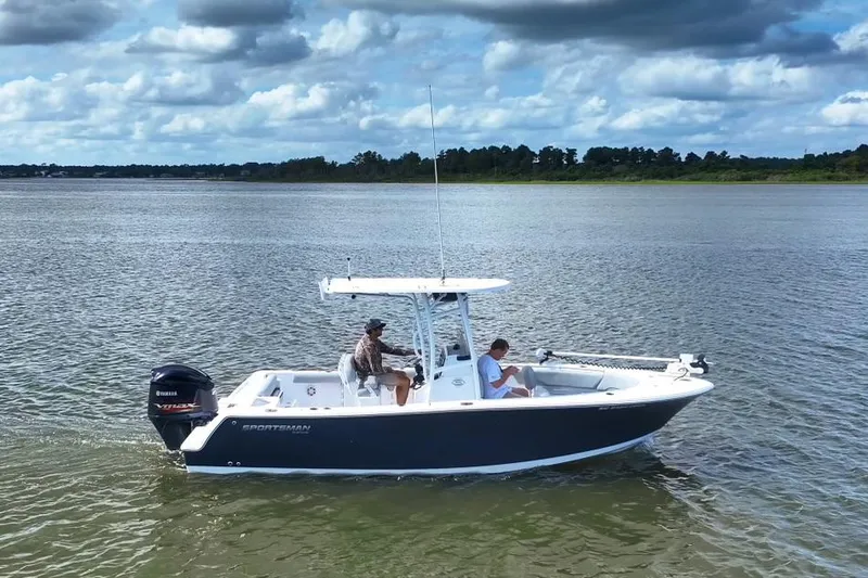 The Image of 2020 Sportsman Open 232 Center Console boat on calm water under cloudy sky. - 0