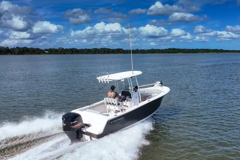 Slide: The Image of 2020 Sportsman Open 232 Center Console boat cruising on a sunny lake. - 1