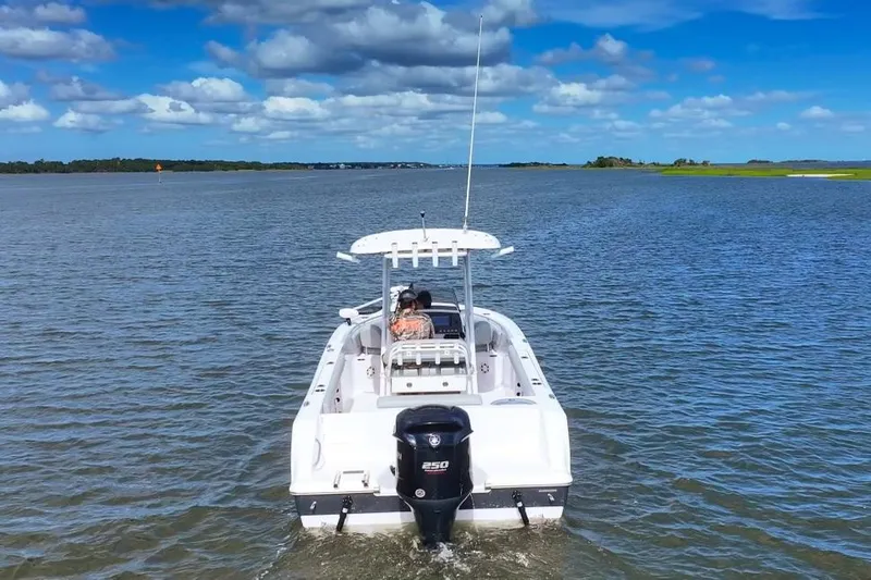 Slide: The Image of 2020 Sportsman Open 232 Center Console boat on calm water under blue sky. - 12