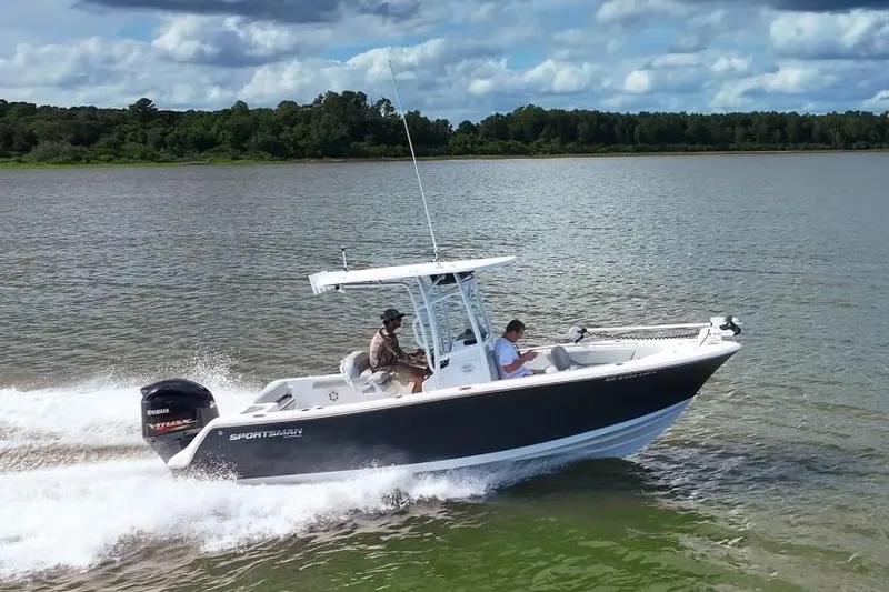 Slide: The Image of 2020 Sportsman Open 232 Center Console boat cruising on a lake under a cloudy sky. - 13