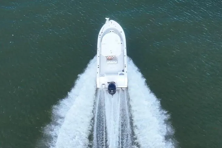 Slide: The Image of Aerial view of 2020 Sportsman Open 232 Center Console boat speeding on water. - 15