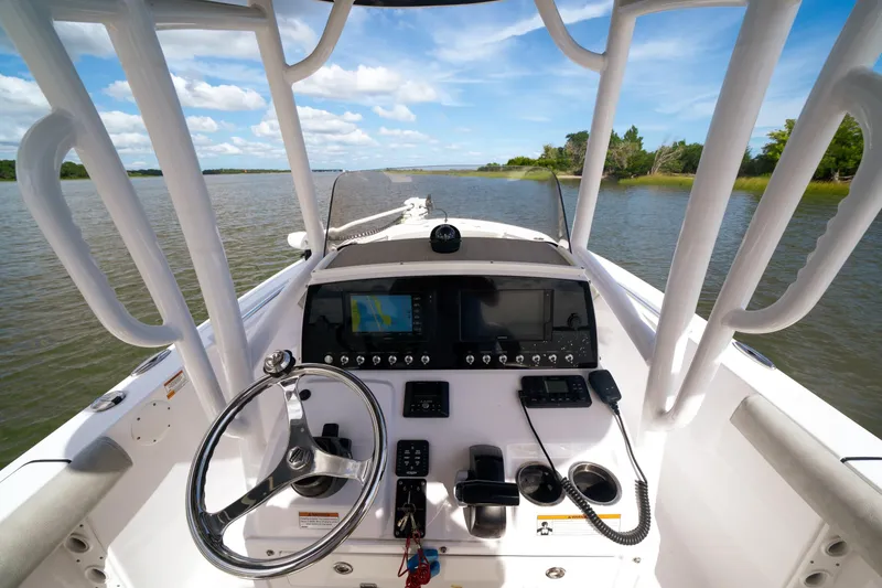 Slide: The Image of 2020 Sportsman Open 232 Center Console boat interior with steering wheel and navigation equipment. - 2