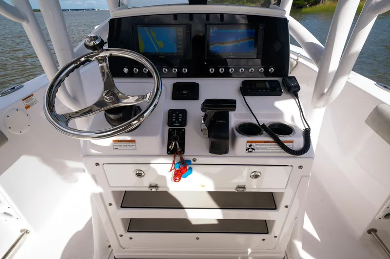 Slide: The Image of 2020 Sportsman Open 232 Center Console boat dashboard with steering wheel and navigation screens. - 3