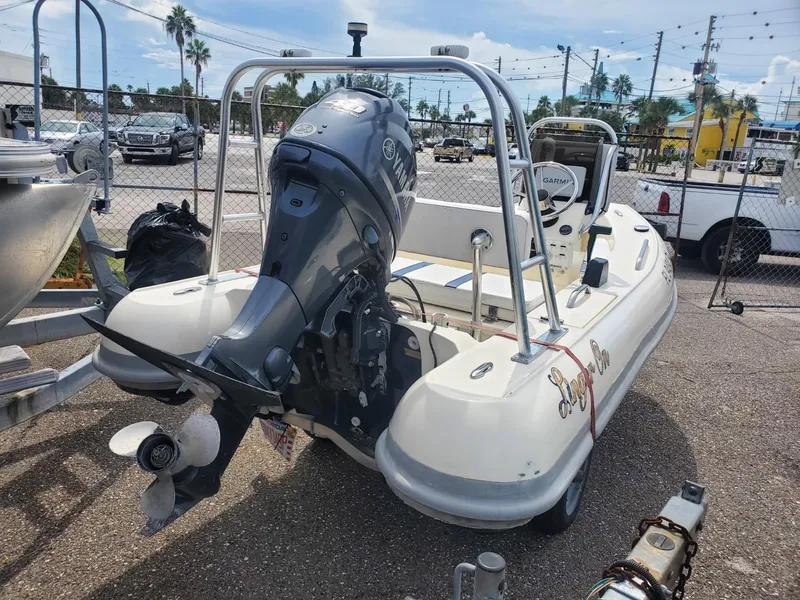 Slide: The Image of 2013 Rigid Boats 12 Sport with outboard motor in a parking lot. - 14