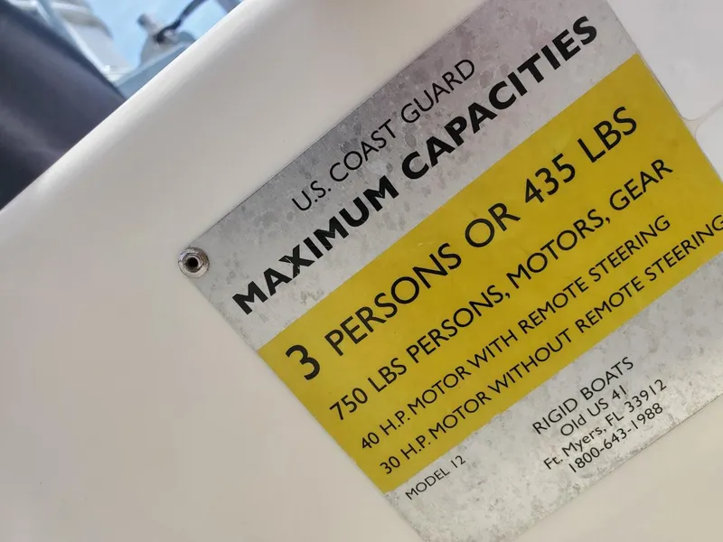 Slide: The Image of U.S. Coast Guard capacity label on 2013 Rigid Boats 12 Sport, detailing weight and passenger limits. - 16