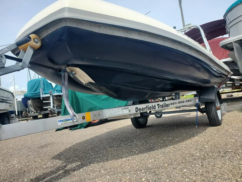 Slide: The Image of 2013 Rigid Boats 12 Sport on Deerfield trailer, parked in a boatyard. - 2