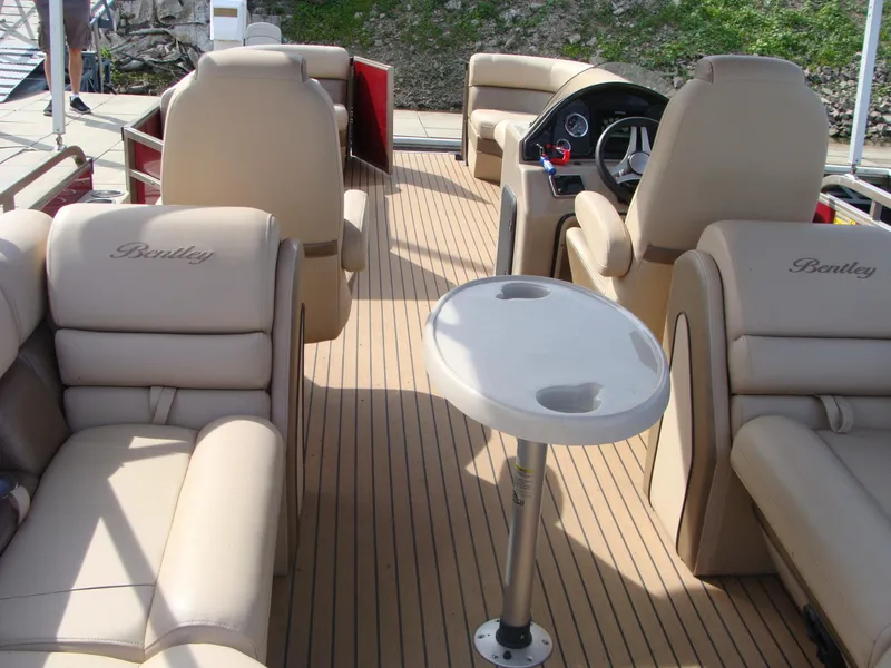 Slide: The Image of 2019 Bentley Pontoons 253 Admiral Elite interior with beige seating and steering console. - 11