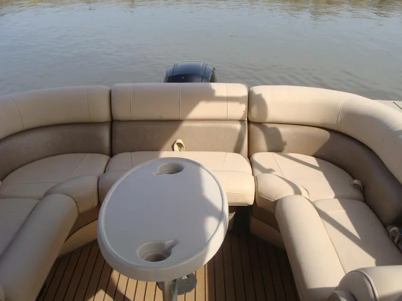 Slide: The Image of 2019 Bentley Pontoons 253 Admiral Elite interior with beige seating and table on water. - 5