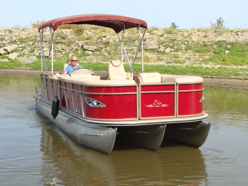 Slide: The Image of 2019 Bentley Pontoons 253 Admiral Elite on calm water, featuring a red canopy. - 7