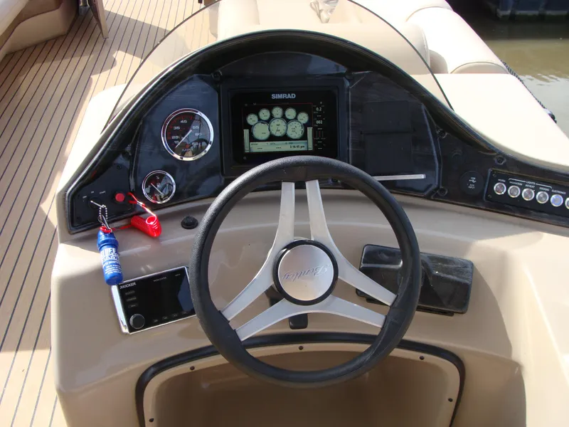 Slide: The Image of 2019 Bentley Pontoons 253 Admiral Elite dashboard with steering wheel and control panel. - 8