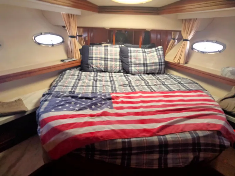 Slide: The Image of Interior of 1999 Carver 530 Voyager Pilothouse with bed and American flag. - 15