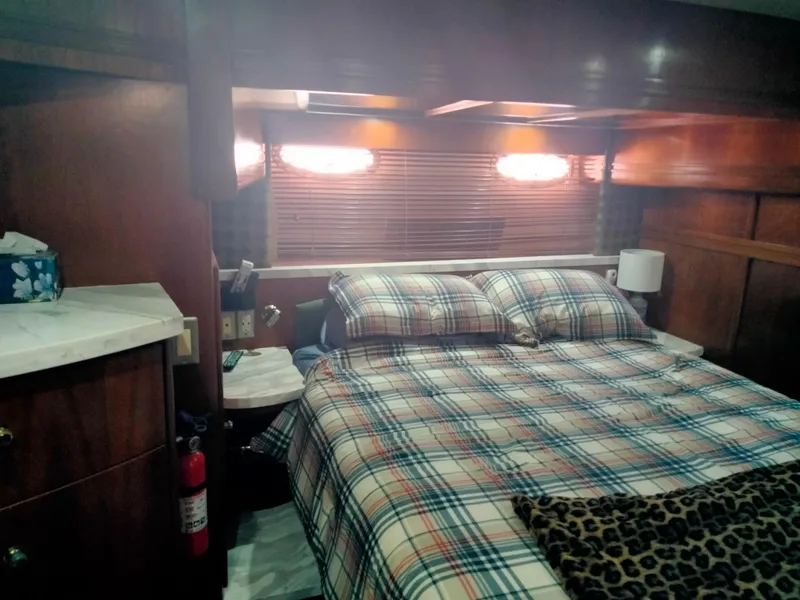 Slide: The Image of Interior of Carver 530 Voyager Pilothouse, cozy bedroom with plaid bedding. - 21