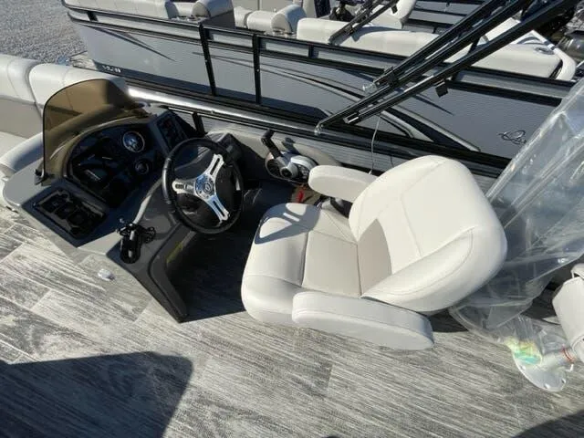 Slide: The Image of 2023 Qwest Pontoons E-Class XRE Cruise 822 LT interior with steering wheel and captain's chair. - 10