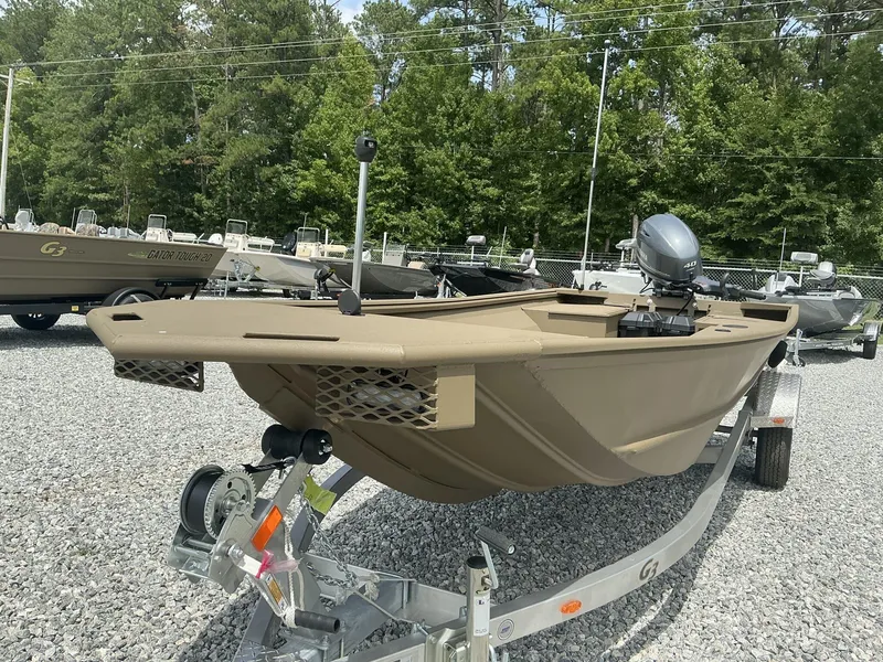 Slide: The Image of 2025 G3 Gator Tough 15 DK boat on trailer, parked on gravel lot. - 11