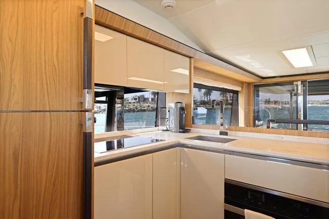 Slide: The Image of Luxurious yacht kitchen interior with modern design, featuring wood accents and large windows overlooking the sea. - 25