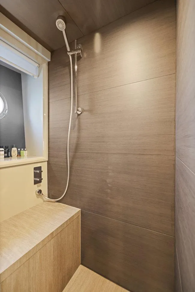 Slide: The Image of Luxurious yacht shower with modern fixtures, wooden accents, and natural lighting. - 47