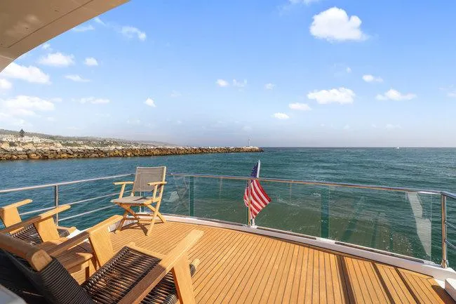 Slide: The Image of Luxury yacht deck with wooden chairs, ocean view, and American flag; Absolute Fly 2015 model. - 7