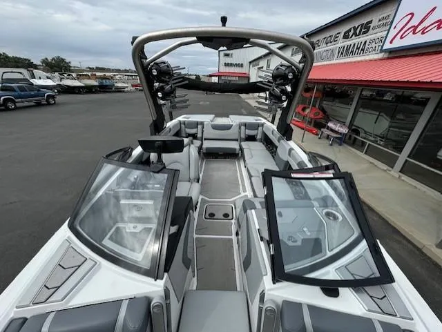 Slide: The Image of 2021 Malibu M240 boat with open cockpit, sleek design, and modern features at a dealership. - 14