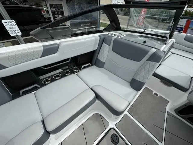 Slide: The Image of 2021 Malibu M240 boat interior with gray and white seating, modern design, and spacious layout. - 16